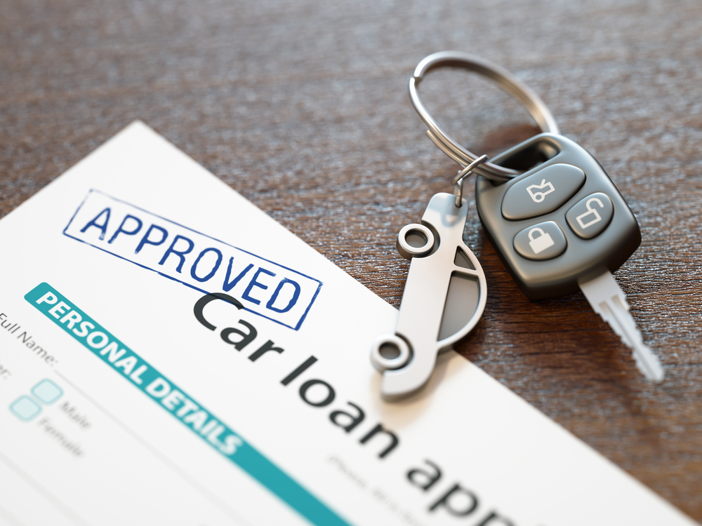Car keys placed on approved auto loan documents, symbolizing vehicle financing and purchase approval. 